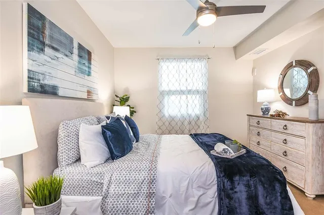 a bedroom with a bed mirror and window
