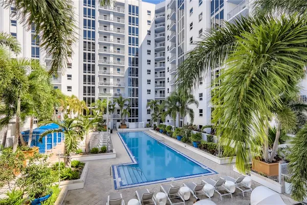a swimming pool with outdoor seating and plants