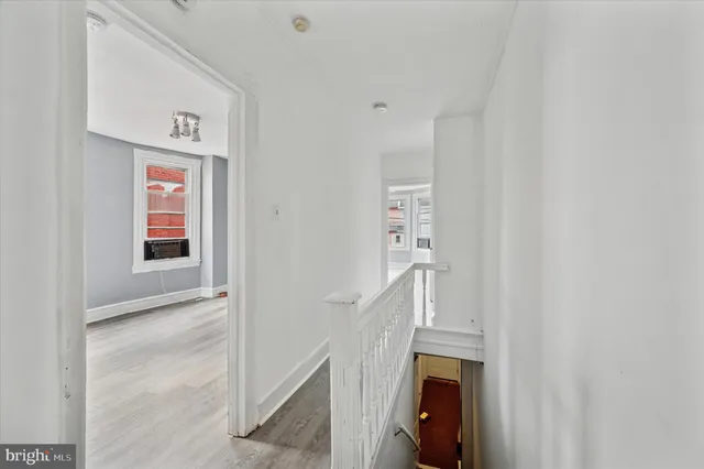 a view of a hallway with wooden floor and entryway