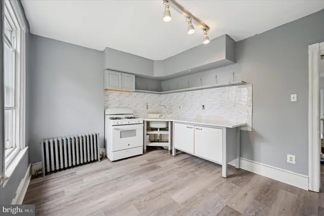 a view of a kitchen with a sink stove and cabinets
