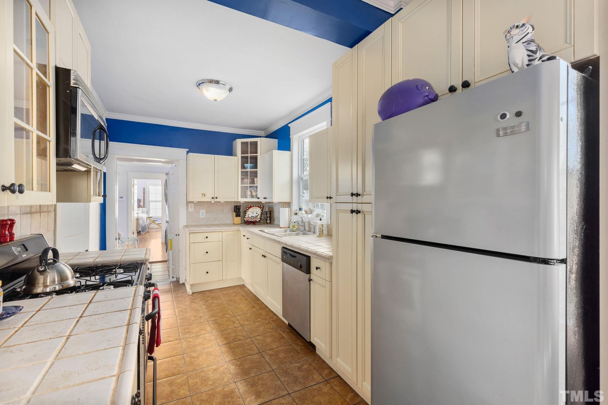 330 Pershing Road Raleigh, NC 27608 - Photo 13 of 51 a kitchen with a refrigerator a sink and cabinets