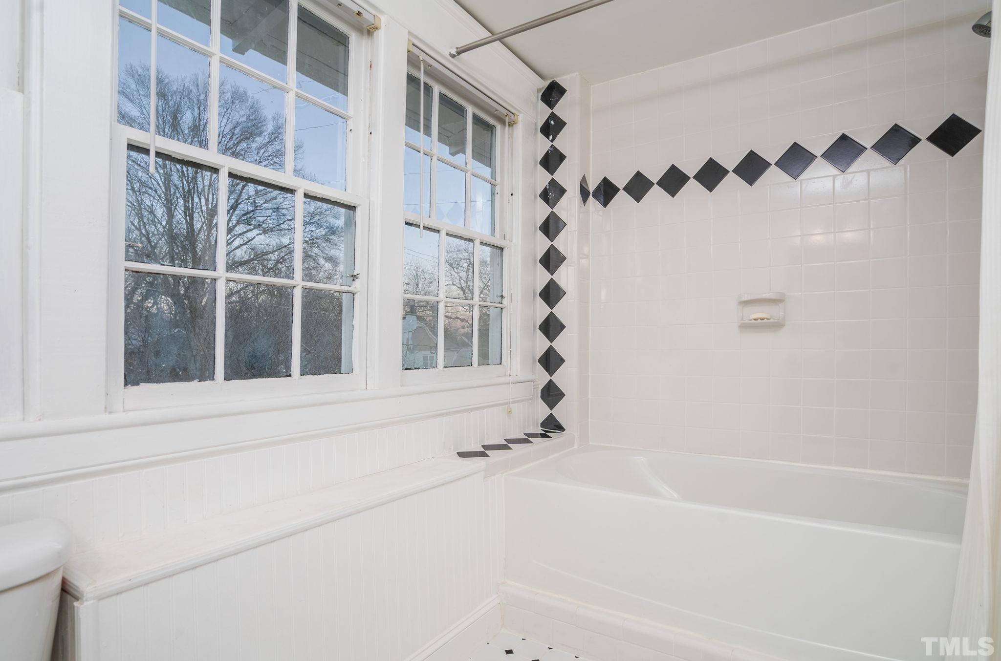 330 Pershing Road Raleigh, NC 27608 - Photo 28 of 51 Tile flooring and tile surround in the tub/shower combination complete the finishes in this bright room, which is full of natural light.