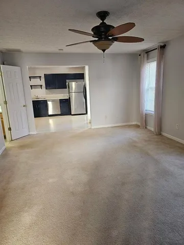 a view of an empty room with a fireplace and a window