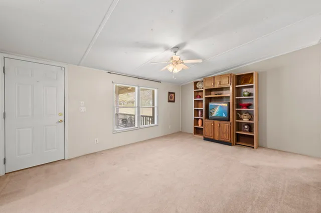 a view of an empty room with window and closet