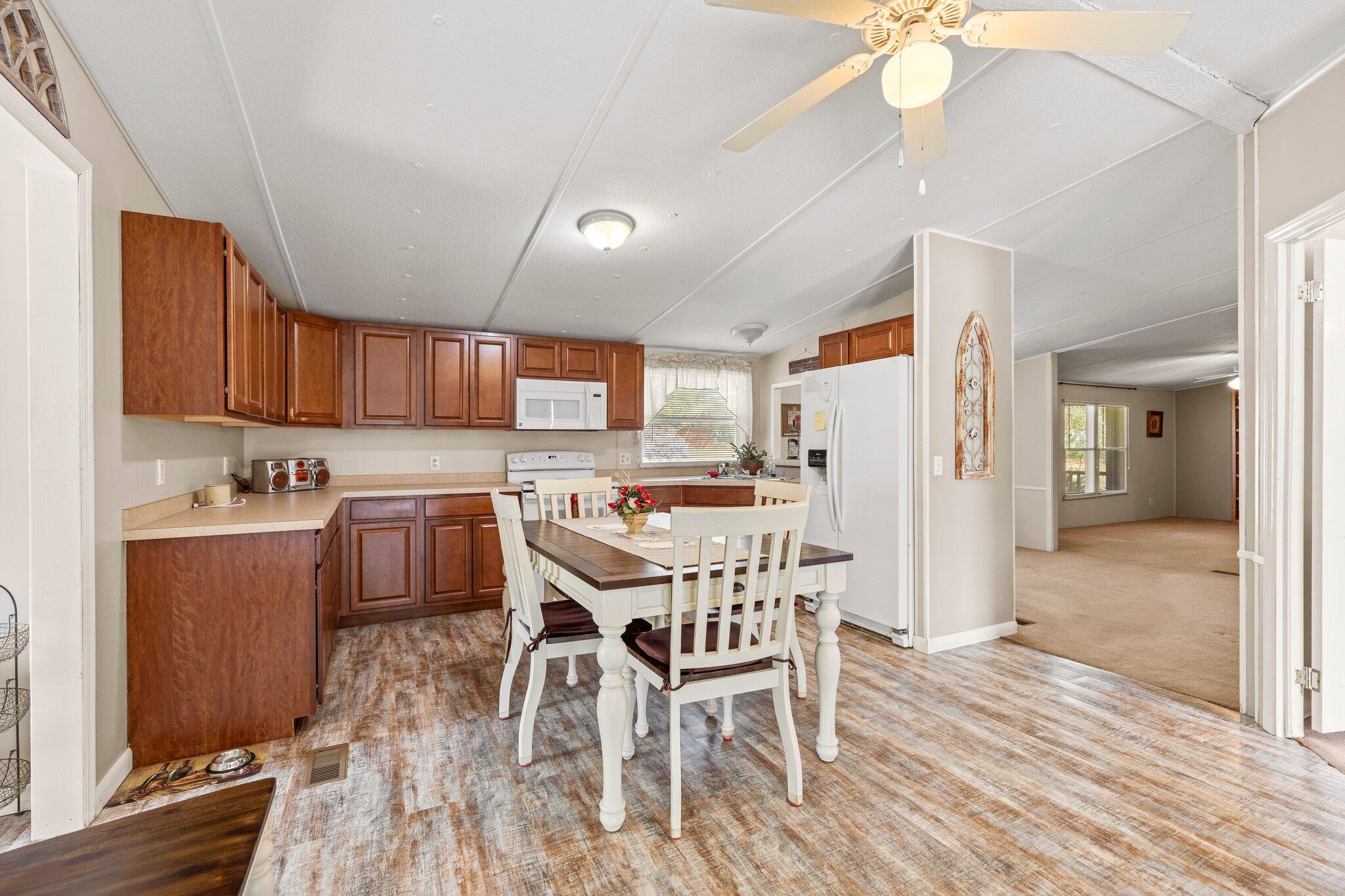 3062 Highland Avenue Crestview, FL 32539 - Photo 22 of 58 a kitchen with stainless steel appliances kitchen island granite countertop a refrigerator a stove a microwave oven with a dining table and chairs