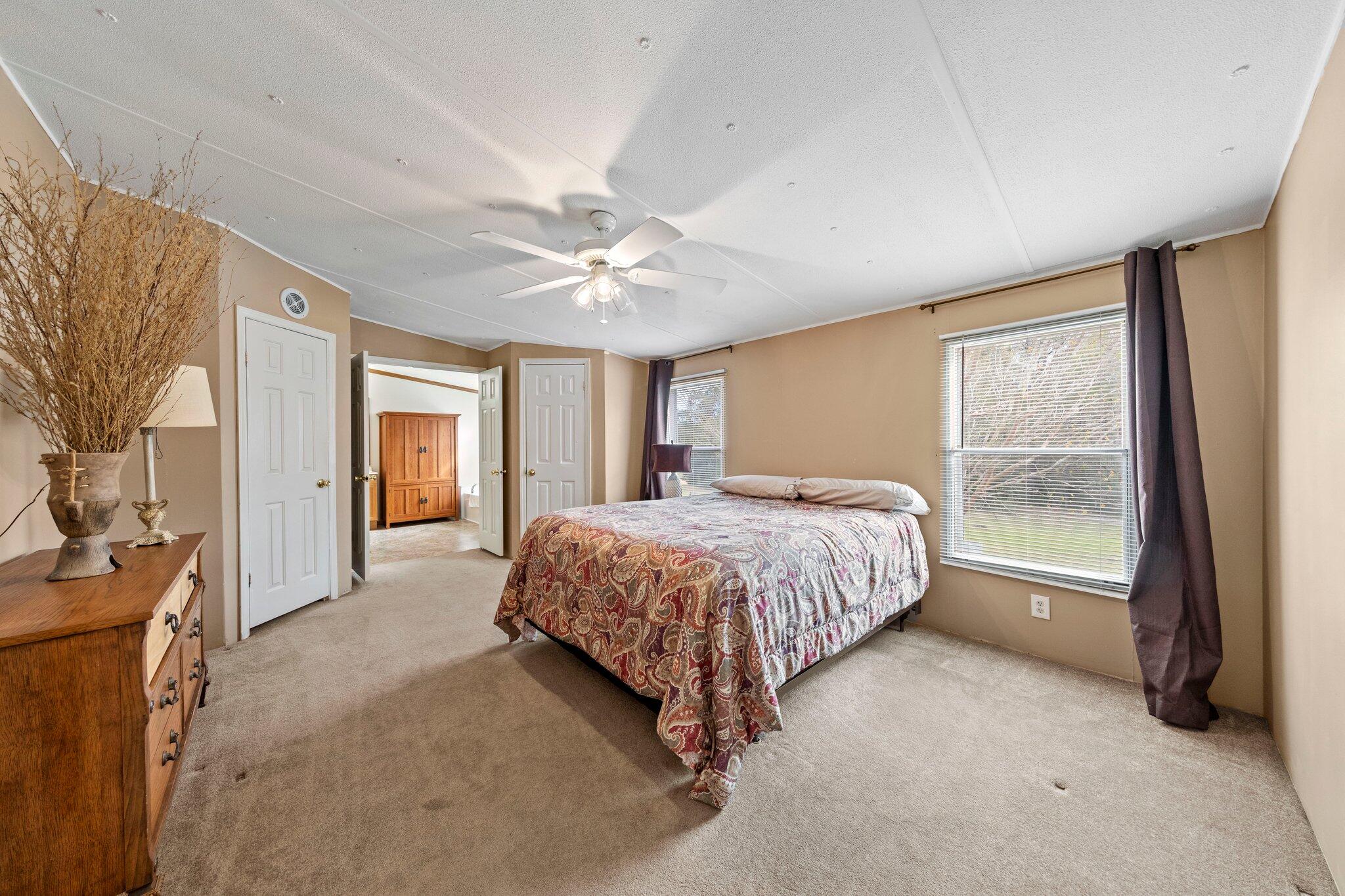 3062 Highland Avenue Crestview, FL 32539 - Photo 24 of 58 a spacious bedroom with a large bed and a chandelier
