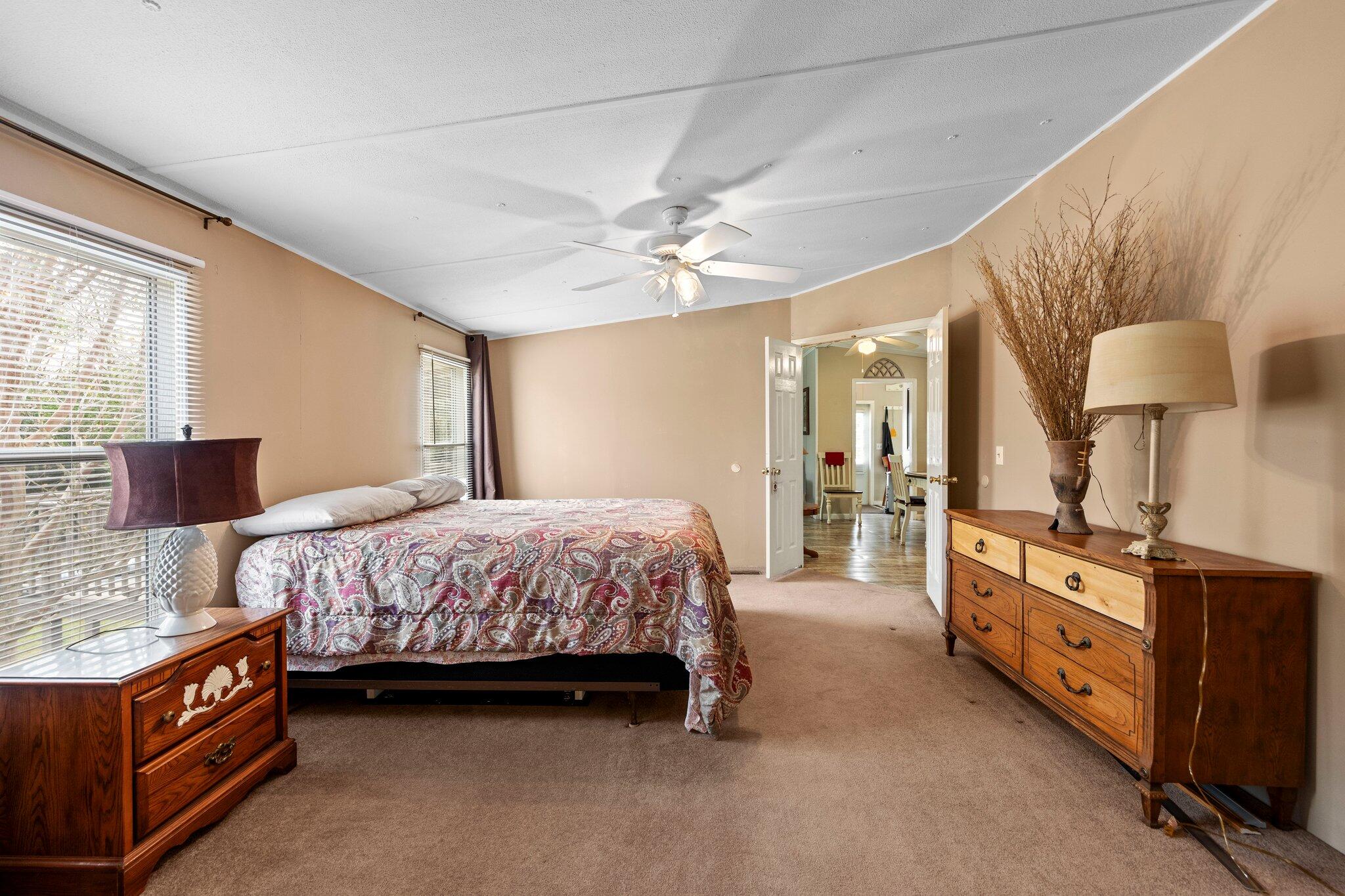 3062 Highland Avenue Crestview, FL 32539 - Photo 26 of 58 a spacious bedroom with a bed and a chandelier