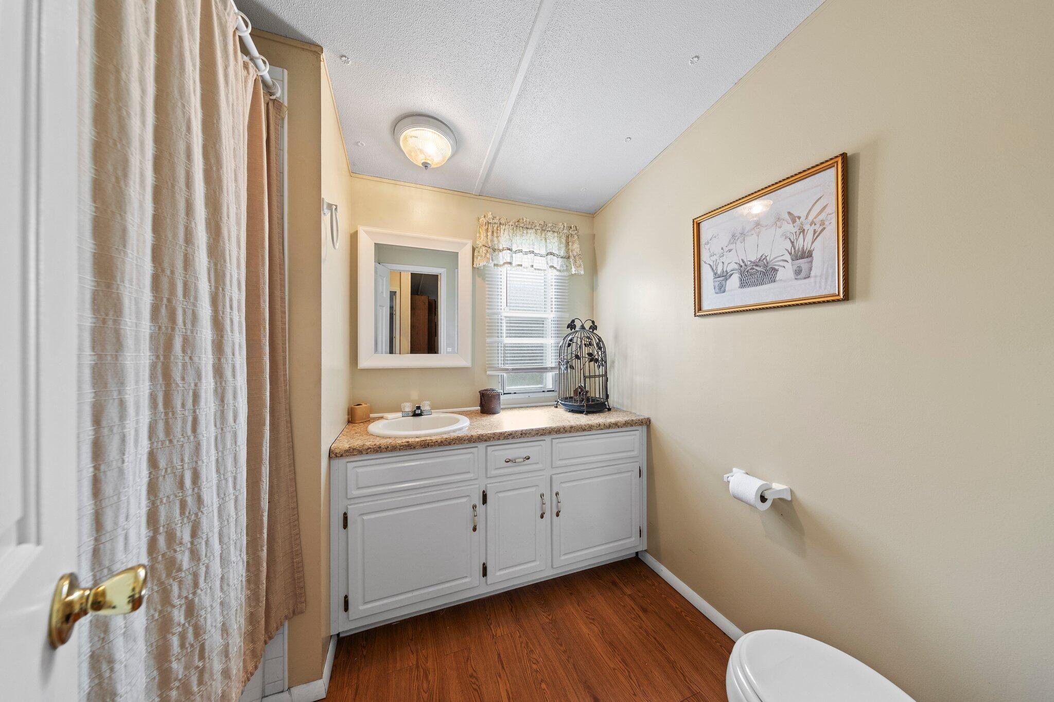 3062 Highland Avenue Crestview, FL 32539 - Photo 37 of 58 a bathroom with a toilet a sink and mirror