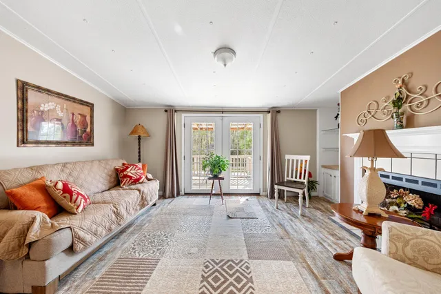 a living room with furniture a flat screen tv and a large window