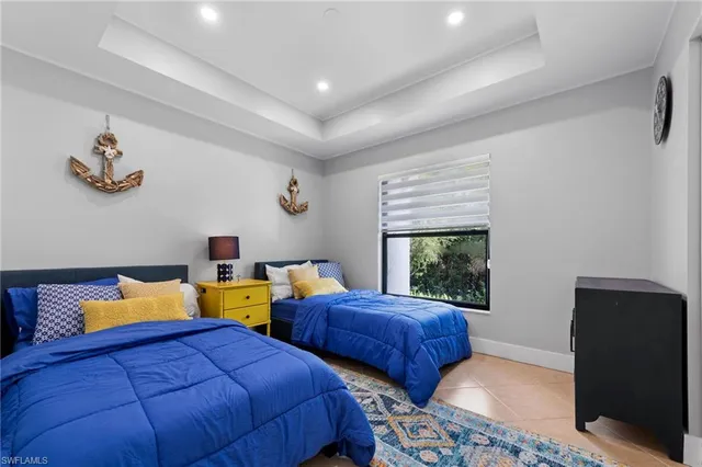 a bedroom with two bed and a window