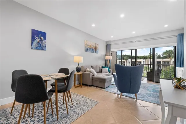 a living room with furniture a lamp and a potted plant