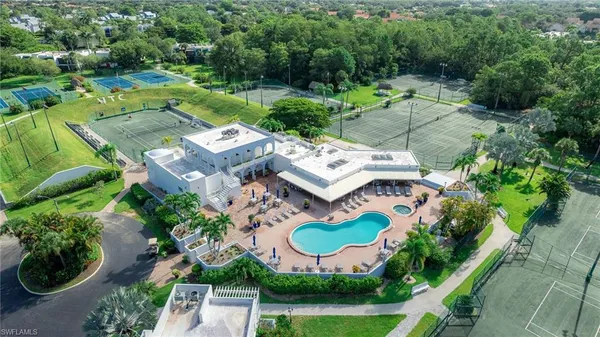 an aerial view of residential houses with outdoor space and trees