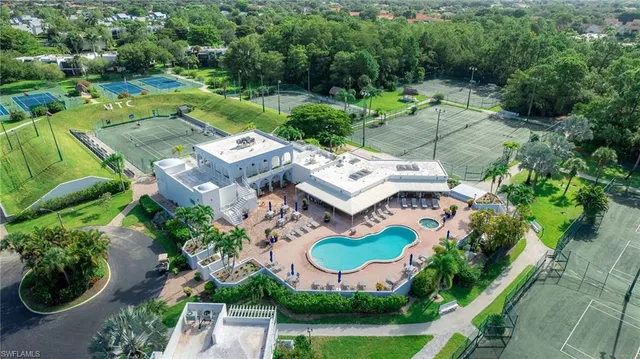 an aerial view of residential houses with outdoor space and trees