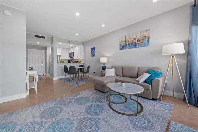 a living room with furniture a rug and a dining table