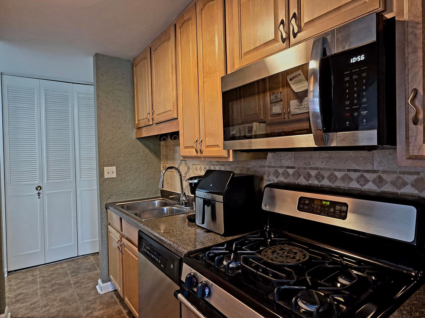 1217 South Old Wilke Road, Unit 201 Rolling Meadows, IL 60005 - Photo 4 of 26 a kitchen with stainless steel appliances granite countertop a stove and a microwave