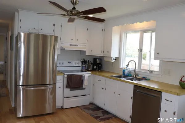 a kitchen with stainless steel appliances a refrigerator sink and cabinets