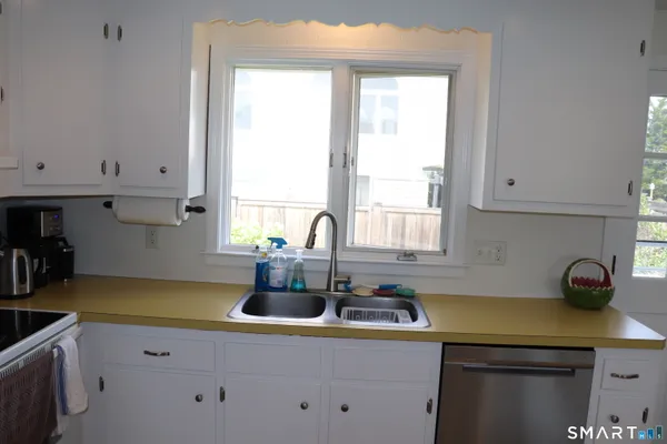 a kitchen with a sink a window and cabinets