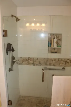 a bathroom with a granite countertop sink a mirror and shower
