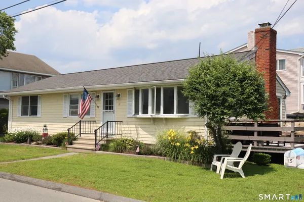 a white house with a yard and a table and chairs