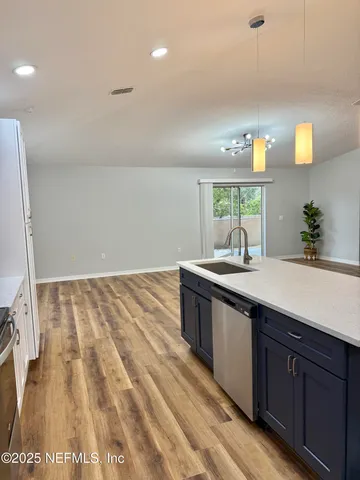 a large kitchen with kitchen island a stove a refrigerator a sink dishwasher with a dining table and chairs