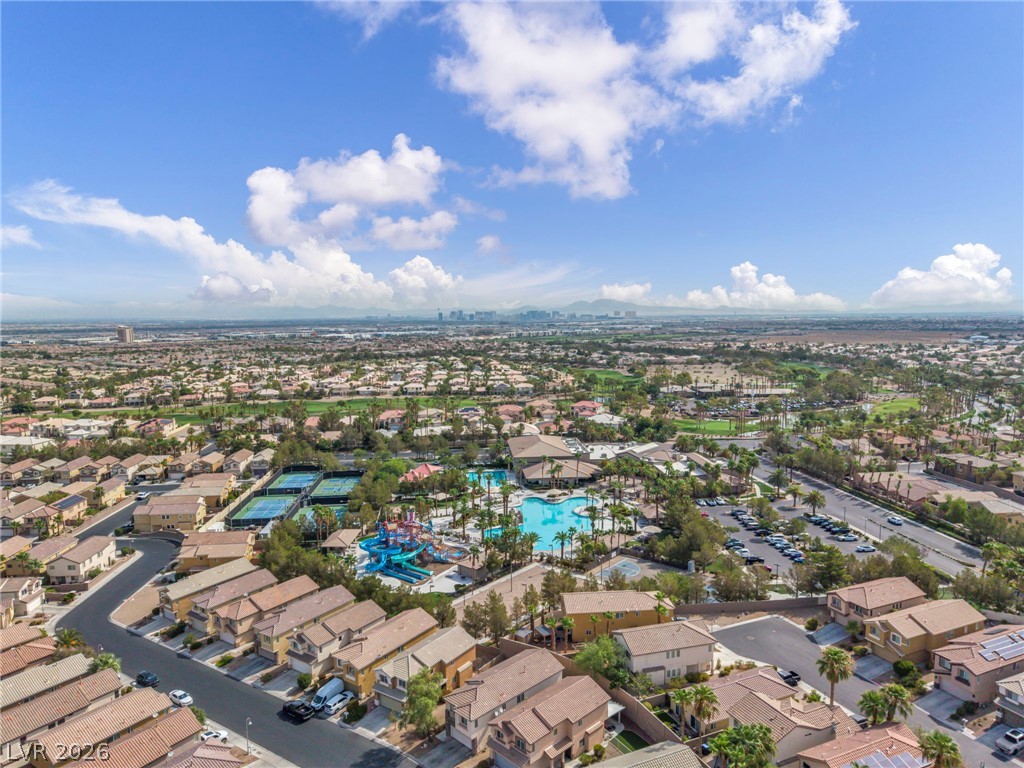 389 Fringe Ruff Drive Las Vegas, NV 89148 - Photo 46 of 53 An aerial perspective reveals a vibrant neighborhood centering around resort-style amenities under a blue sky.