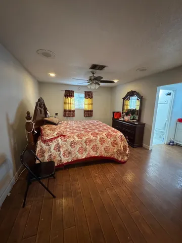 a bed sitting in a bedroom and view of kitchen