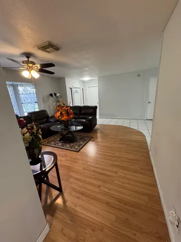 a living room with furniture and a wooden floor