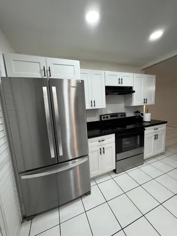 a kitchen with stainless steel appliances a refrigerator sink and cabinets