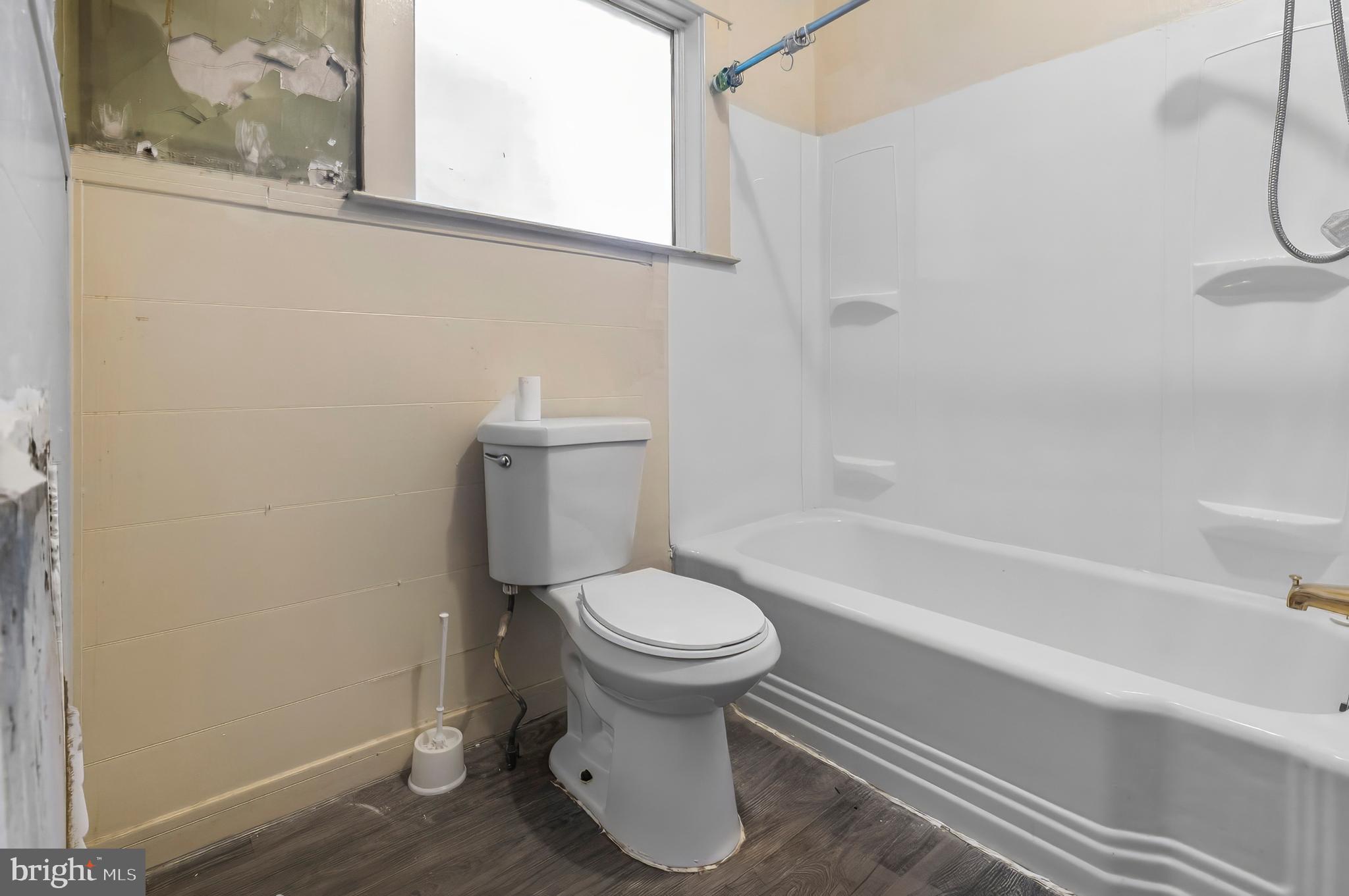 3105 Mareco Avenue Baltimore, MD 21213 - Photo 13 of 27 a white toilet sitting next to a bath tub and a shower