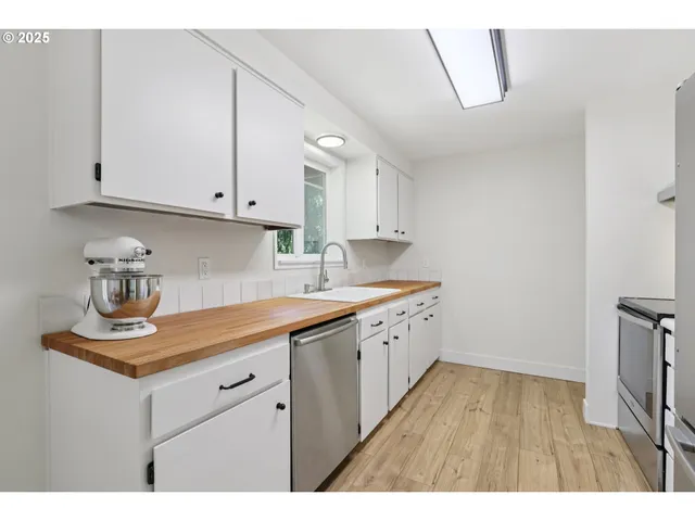 a kitchen with sink cabinets and wooden floor