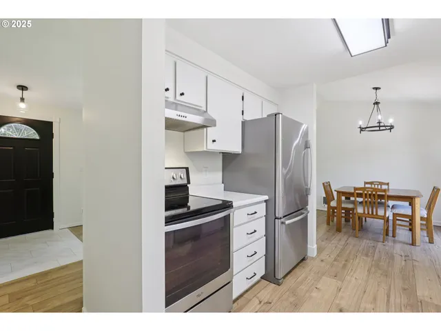 a kitchen with stainless steel appliances a refrigerator and a stove top oven