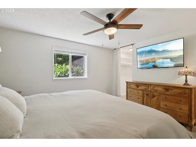 a bedroom with a large bed and a flat screen tv