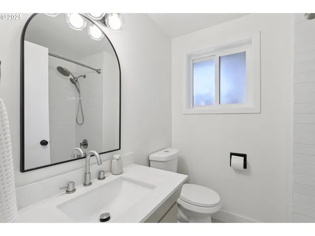 a bathroom with a sink a toilet and mirror
