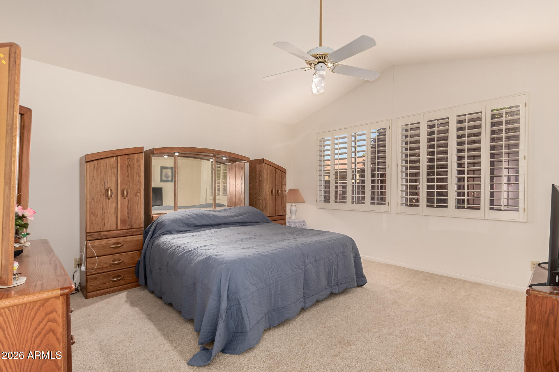 10904 East Spring Creek Road Sun Lakes, AZ 85248 - Photo 20 of 37 a bedroom with a large bed and a chandelier