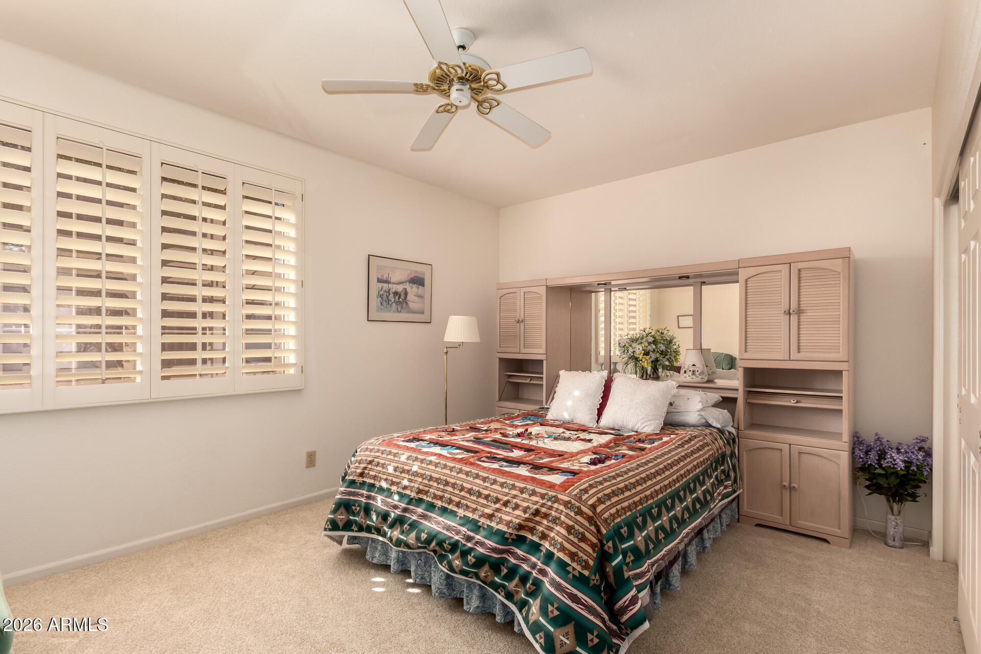 10904 East Spring Creek Road Sun Lakes, AZ 85248 - Photo 26 of 37 a bedroom with a bed a dresser and a large window