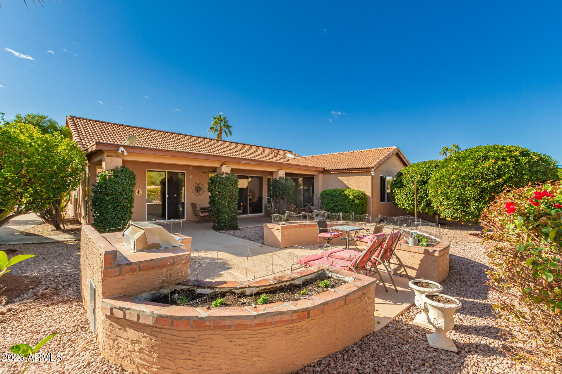 10904 East Spring Creek Road Sun Lakes, AZ 85248 - Photo 34 of 37 a view of a house with backyard sitting area and swimming pool