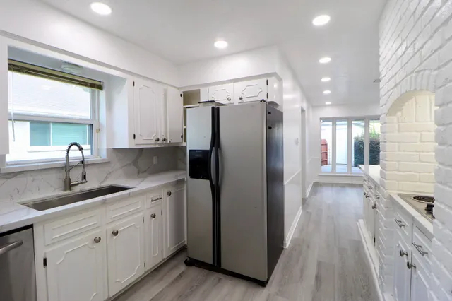 a kitchen with stainless steel appliances granite countertop a refrigerator and a sink