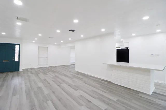 a view of empty room with wooden floor and fireplace