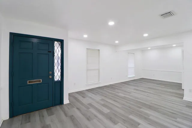 an empty room with wooden floor & closet area