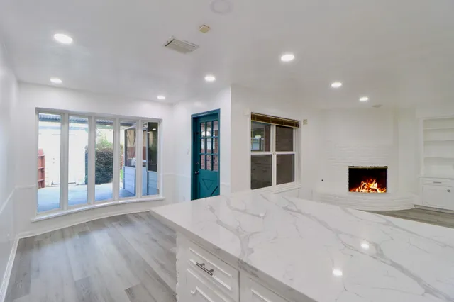 a view of an empty room with a fireplace and a window