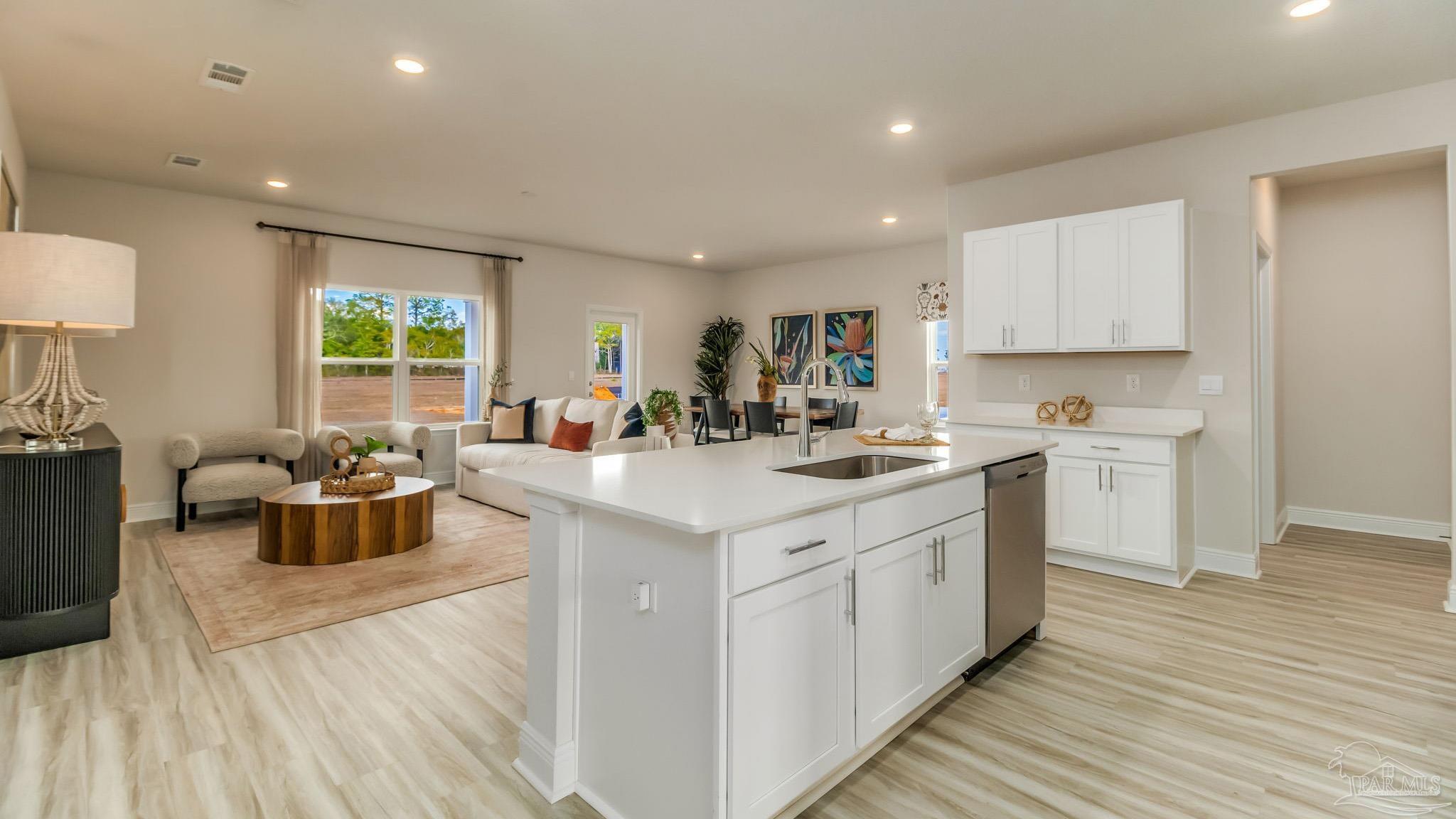 8685 Bluebell Street Milton, FL 32583 - Photo 4 of 30 a kitchen with a sink dishwasher a stove and white cabinets with wooden floor