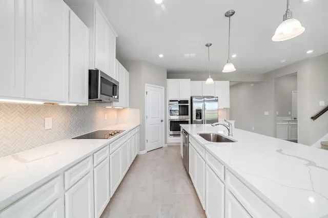 a kitchen with kitchen island a sink and appliances