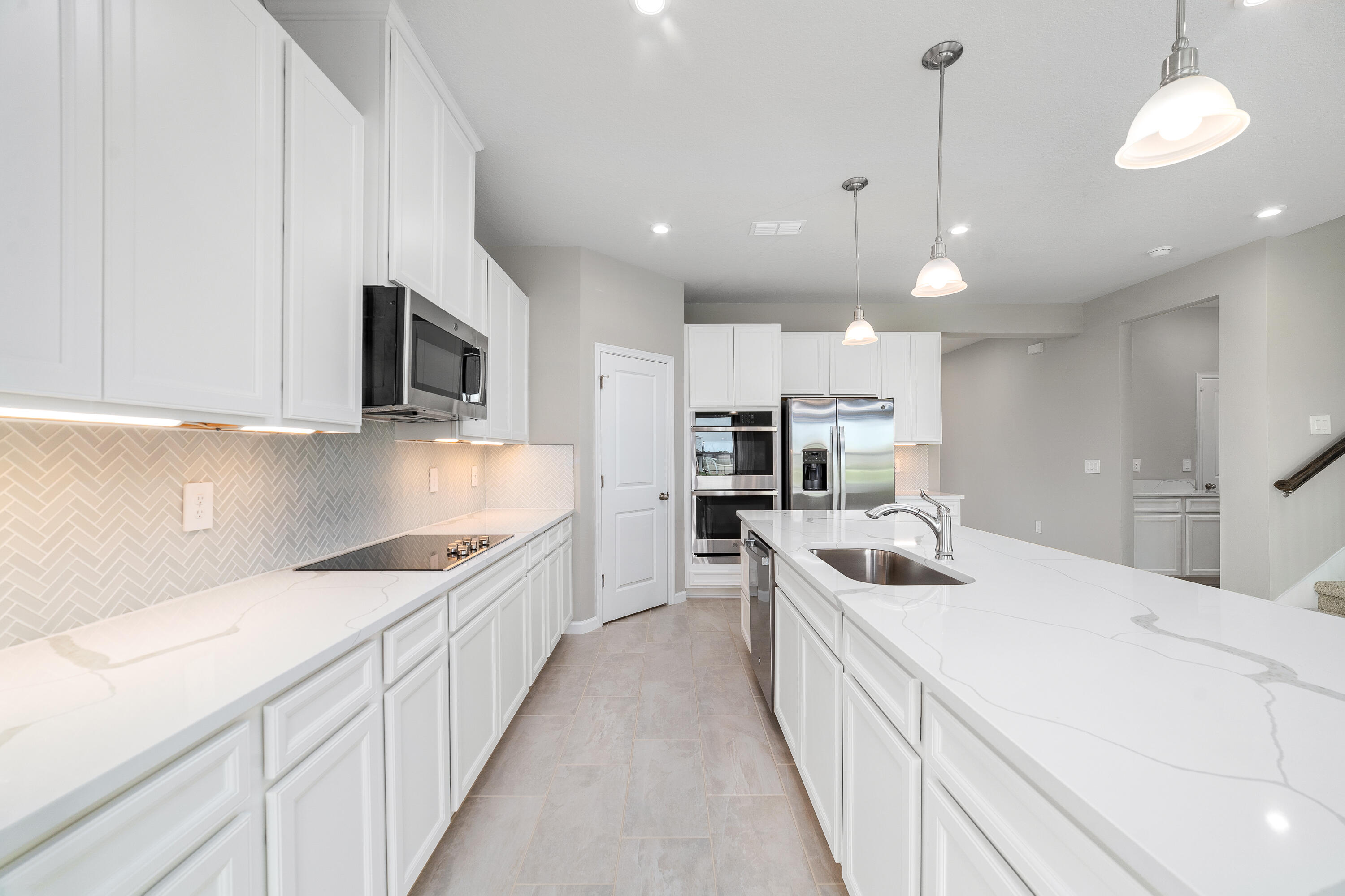 6555 Pomello Court Vero Beach, FL 32967 - Photo 11 of 35 a kitchen with kitchen island a sink and appliances