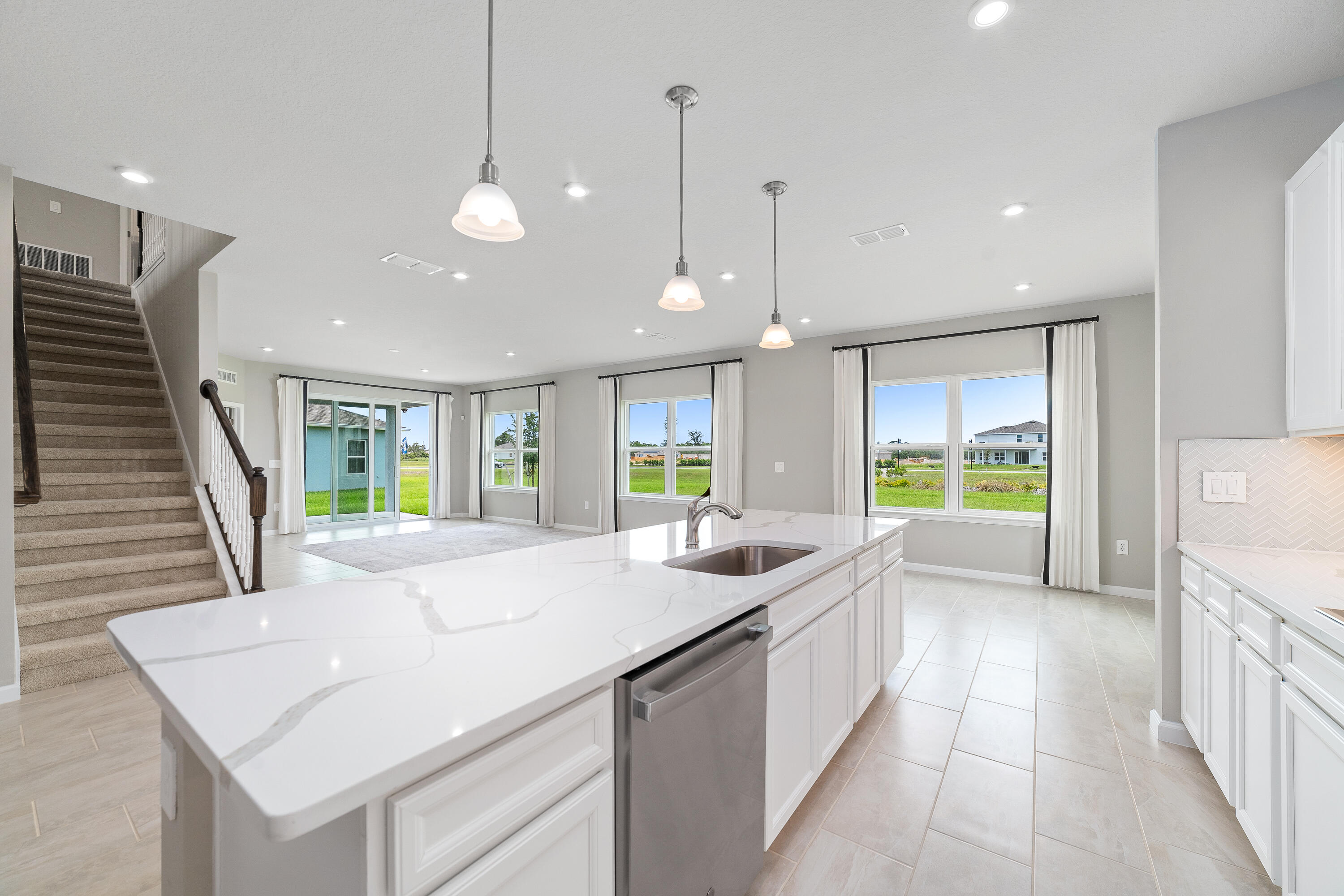 6555 Pomello Court Vero Beach, FL 32967 - Photo 12 of 35 a large white kitchen with a large window and stainless steel appliances