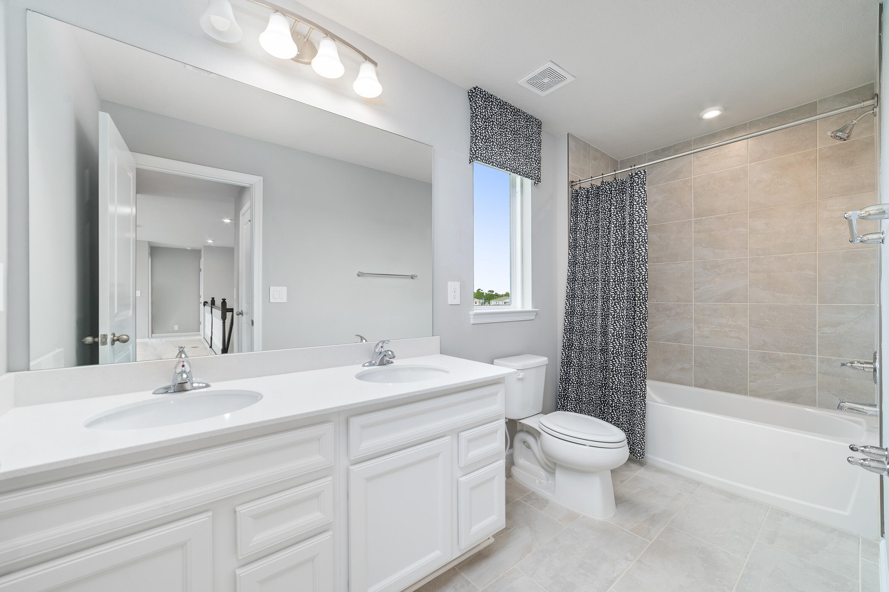 6555 Pomello Court Vero Beach, FL 32967 - Photo 22 of 35 a bathroom with a double vanity sink toilet mirror and shower