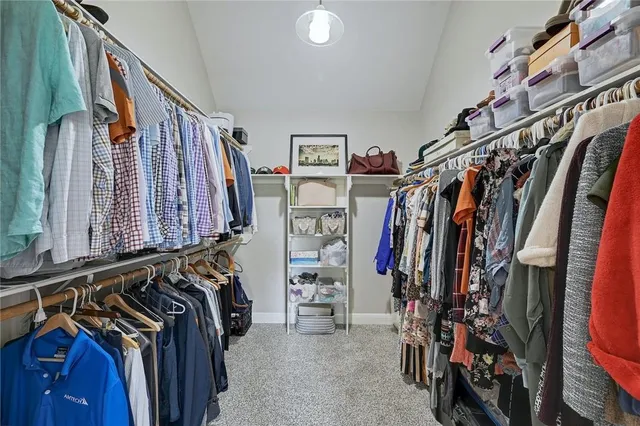 a view of walk in closet with clothes and shoes