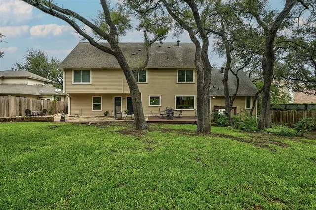 a view of a yard in front of a house with large tree
