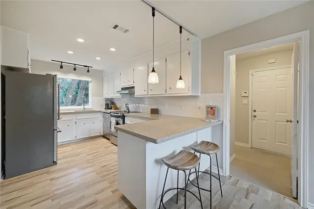 a kitchen with a refrigerator a sink and cabinets
