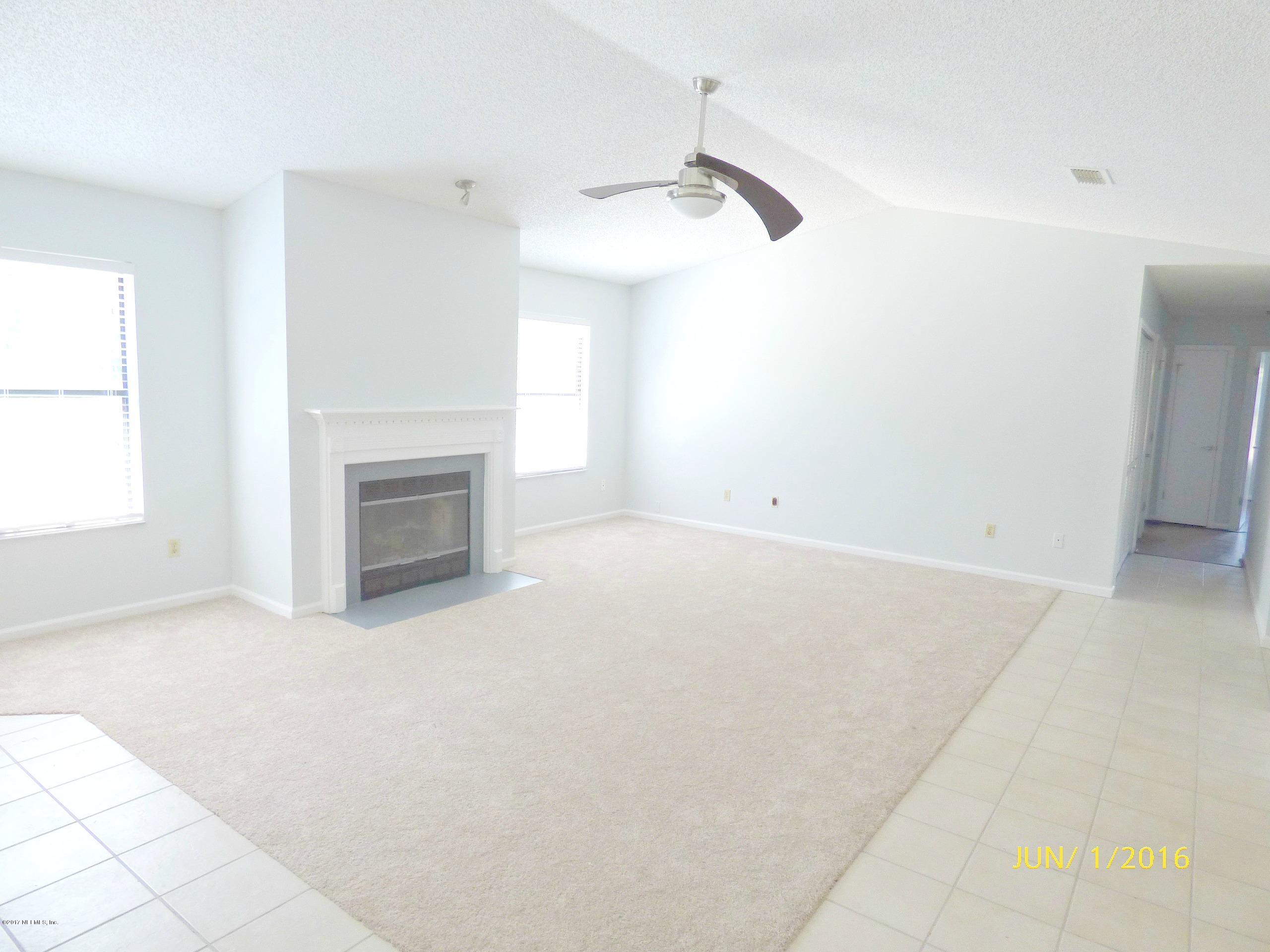 1218 Raleigh Ridge Drive Jacksonville, FL 32225 - Photo 4 of 14 an empty room with windows and fireplace