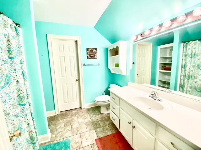 a spacious bathroom with a granite countertop sink and a mirror